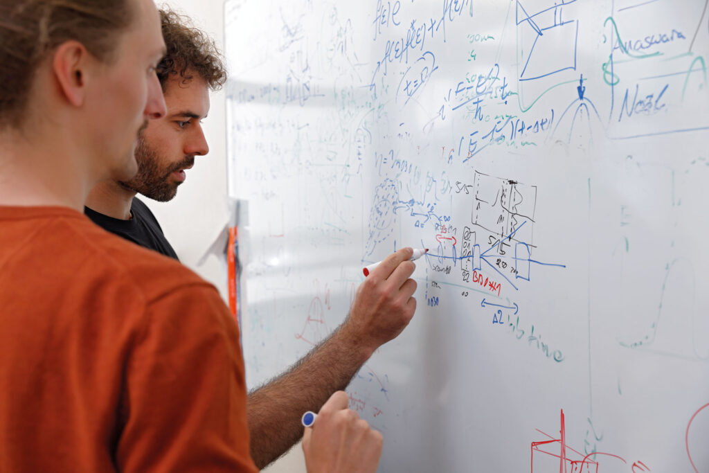 Diskussion des optischen Aufbaus zur Elektronenmodulation mit PhD-Student Magnus Lederer.